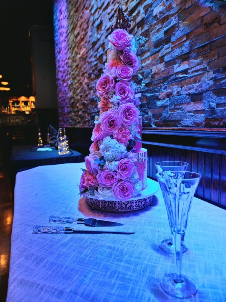 Wedding cake with pink flowers by Butter Bliss Bakeshop