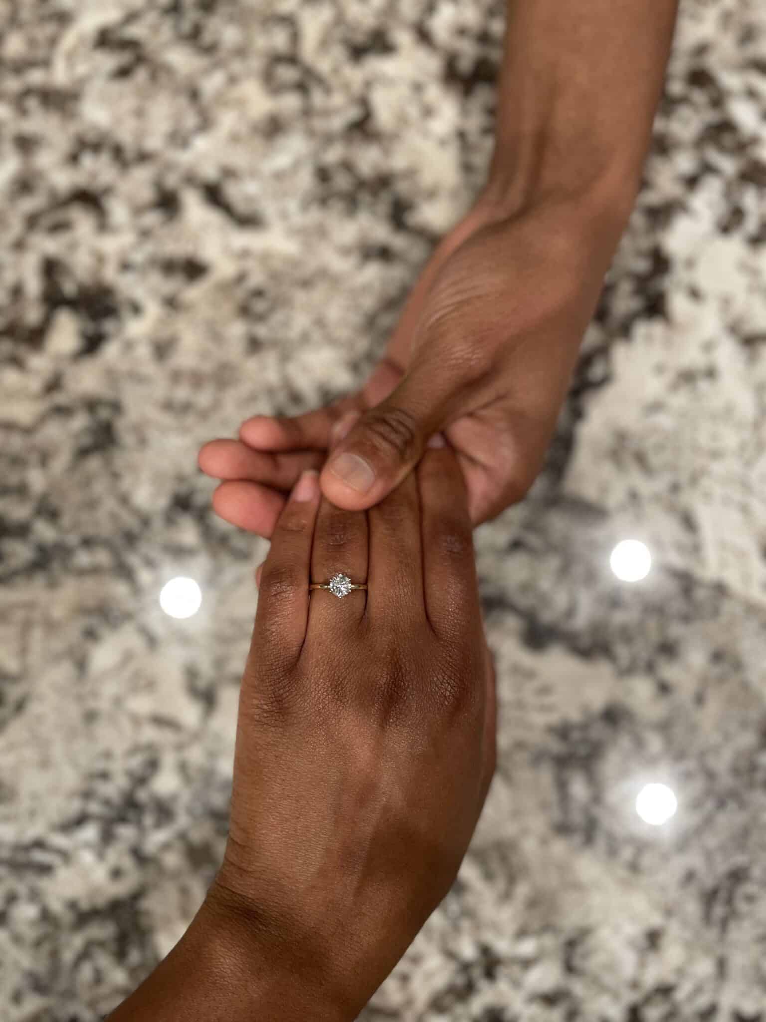 bride's left hand with her new engagement ring.
