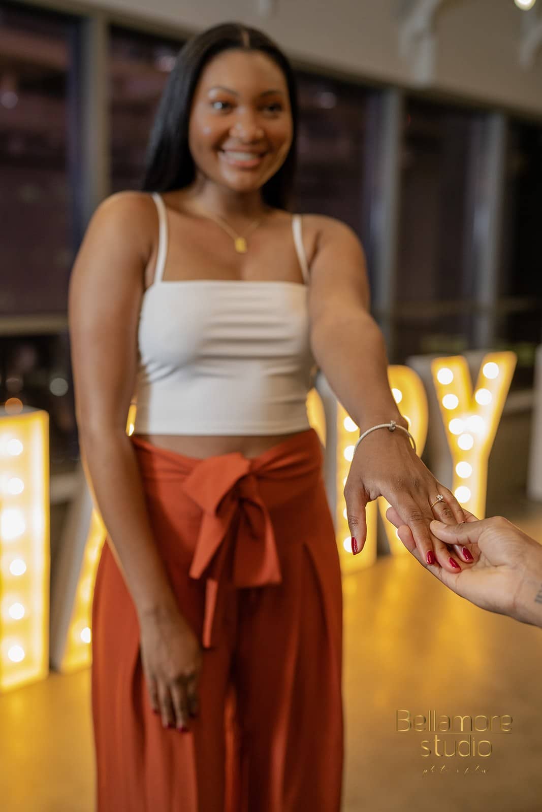 bride to be holding out her left hand to show off her new engagement ring after the downtown orlando marriage proposal.
