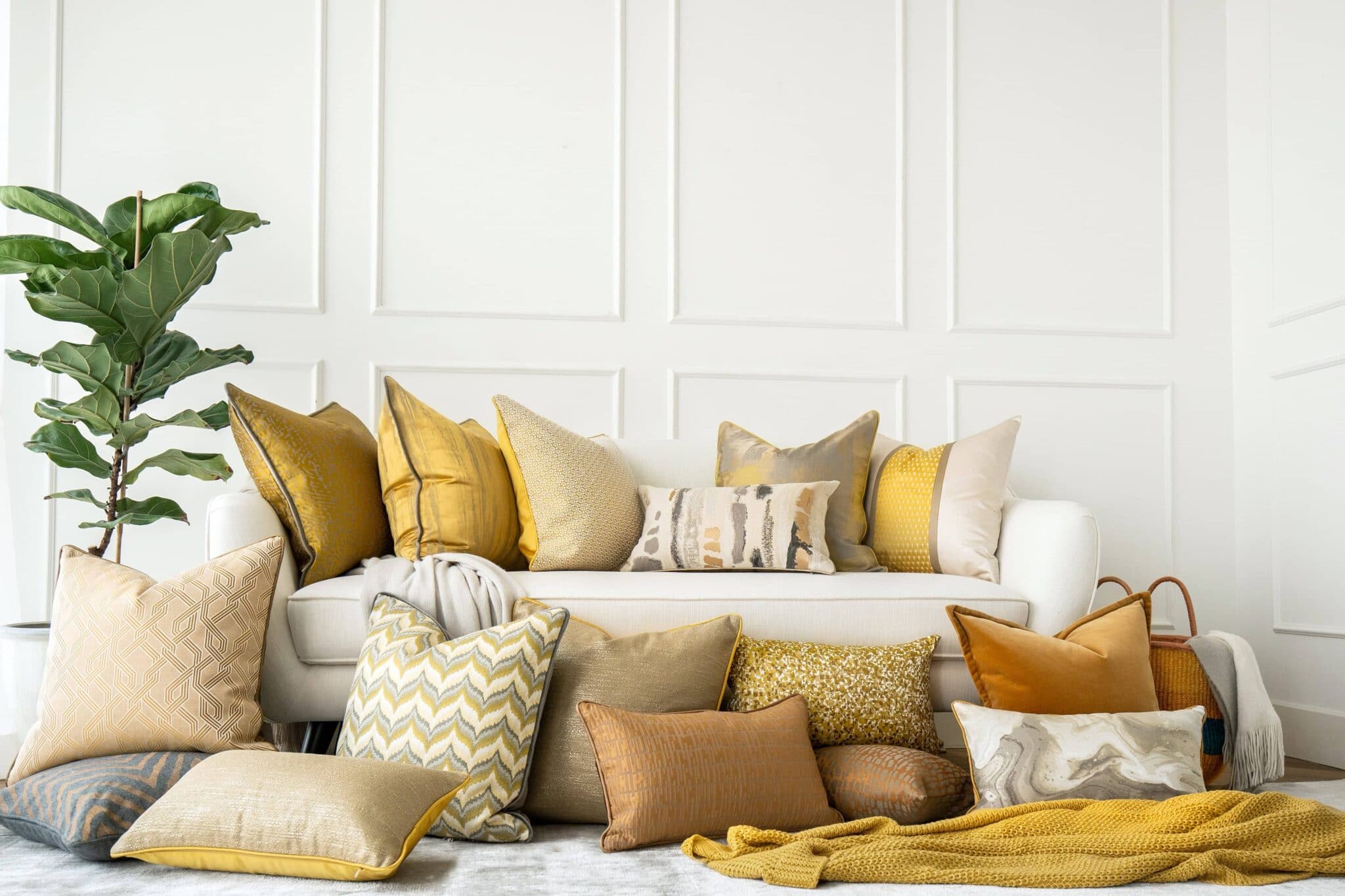 white couch with gold and yellow pillows