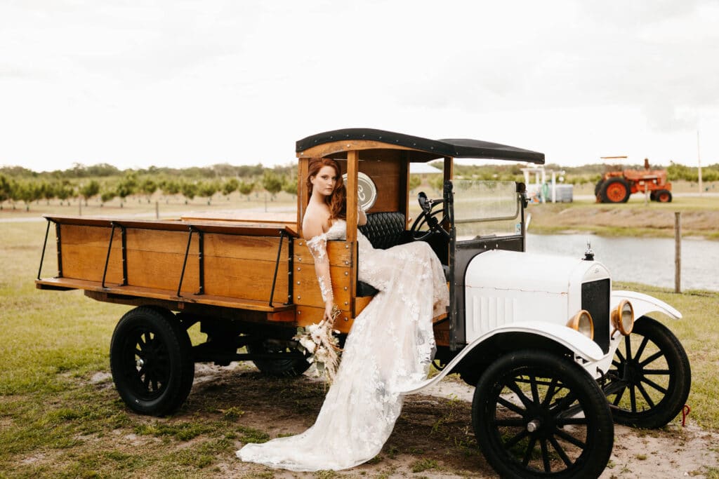 bride sitting in small truck at wedding farm