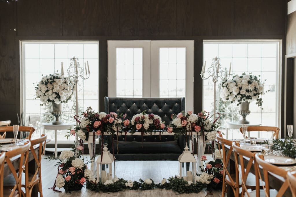 wedding sweetheart table with lanterns and large floral arrangements