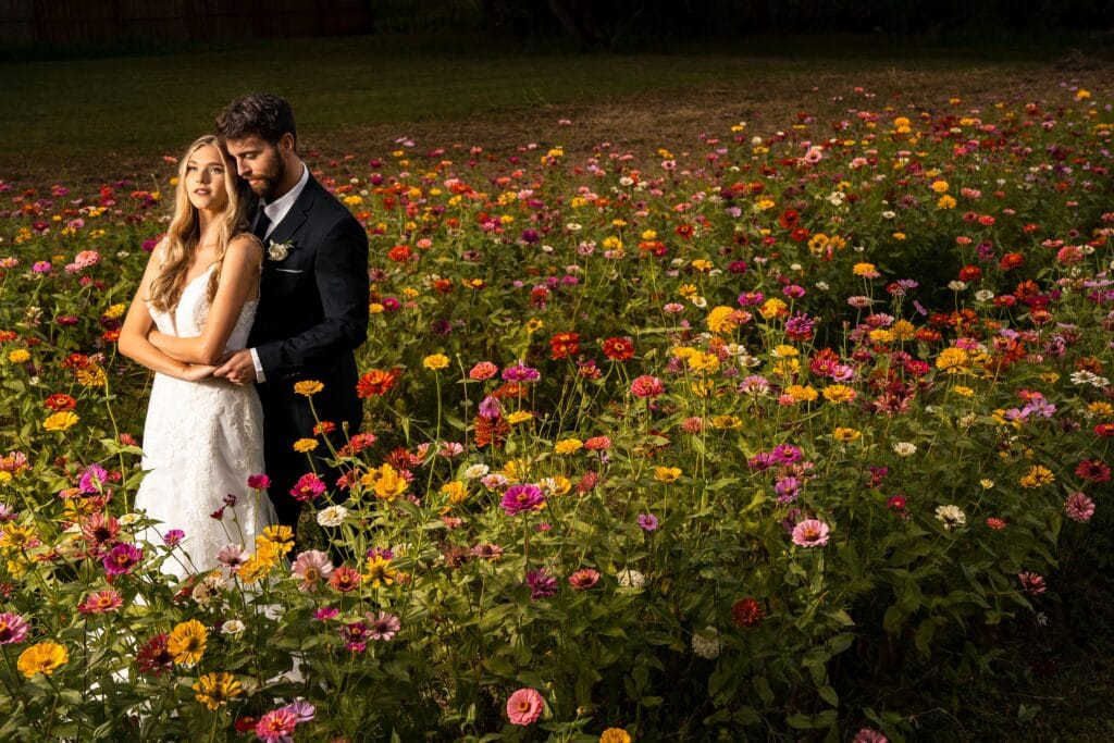 bride and groom standing in field of wildflowers at ever after farms