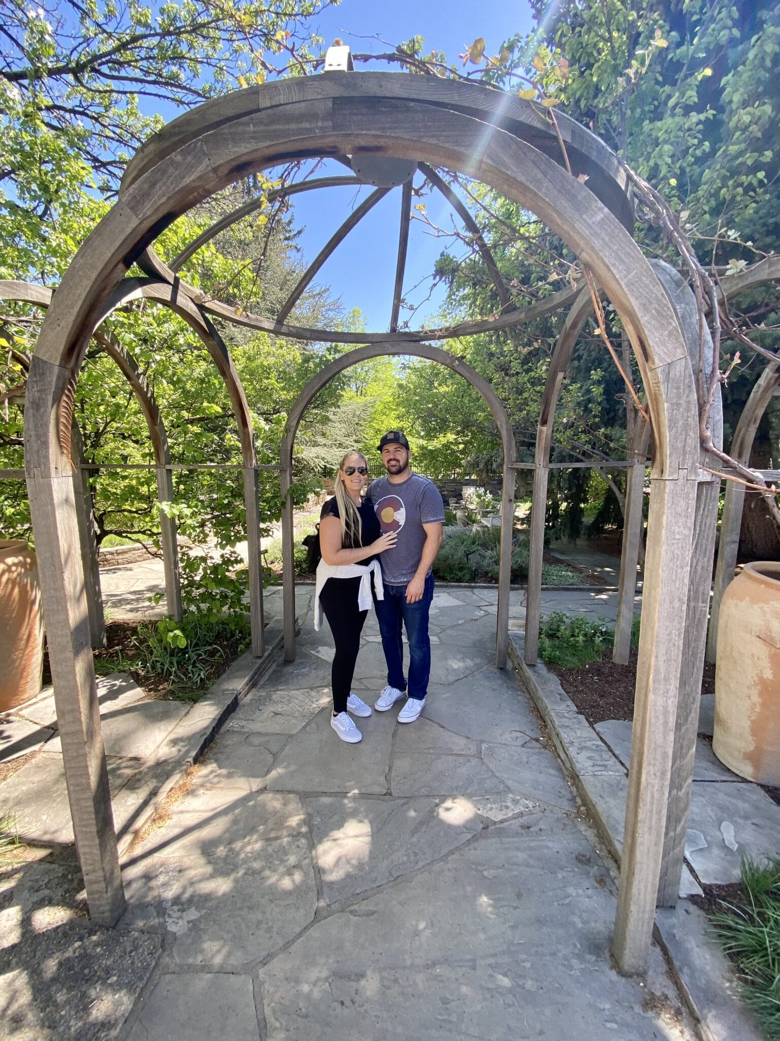 newly married couple standing under a wooden dome.