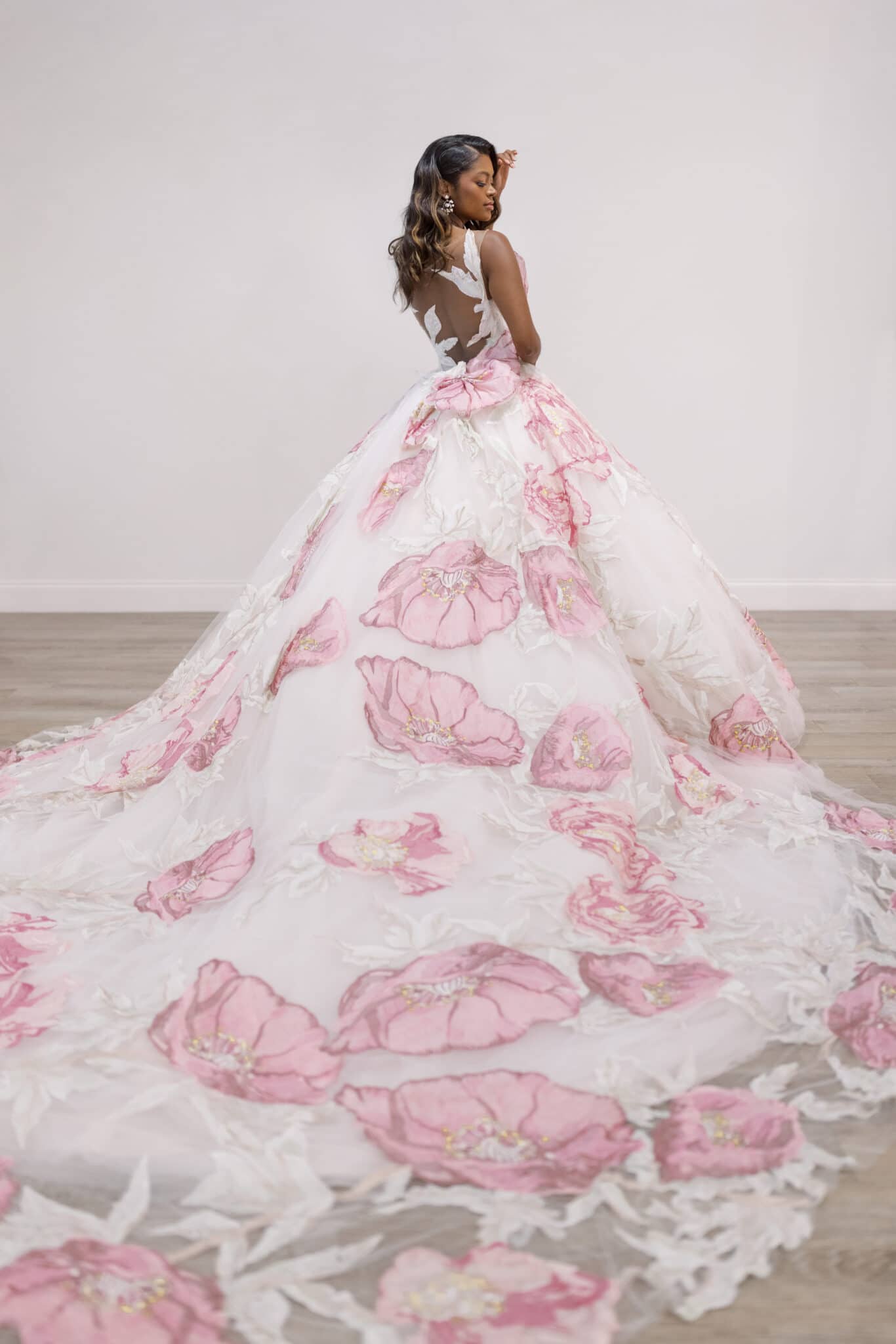 Beautiful bride in her flowing white wedding gown adorned with pink flowers