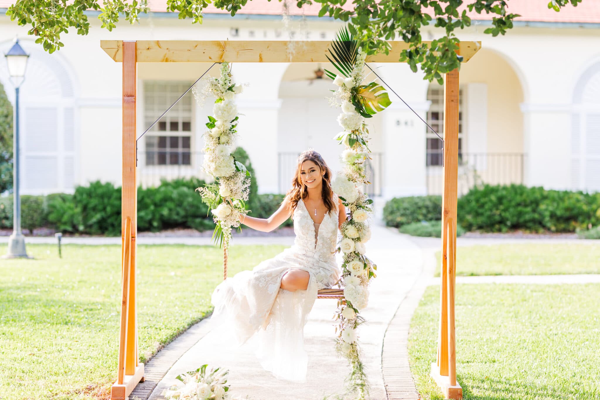 bride sitting on a flower swing for the glamorous gold wedding inspiration shoot.