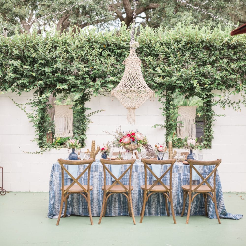 outdoor wedding reception table scape with chandelier by Flowers by Lesley