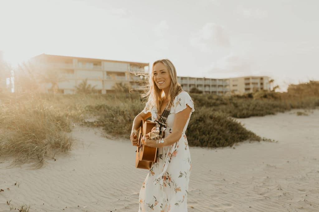 beautiful blond playing guitar on the beach with Aloha Erica Wedding Music