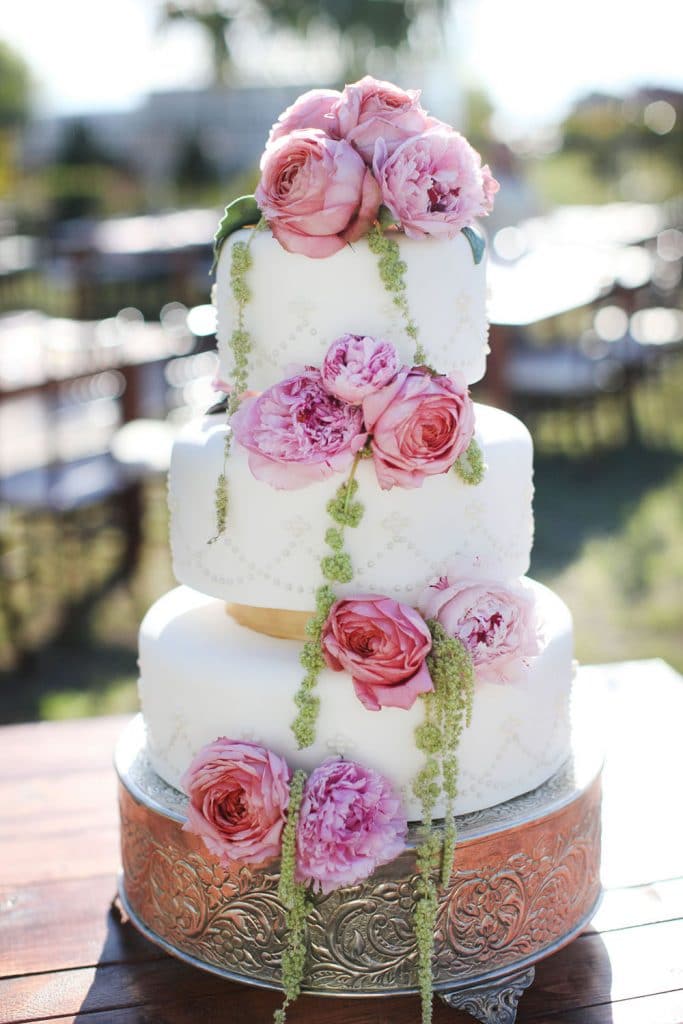 wedding cake with pink flowers decorating it