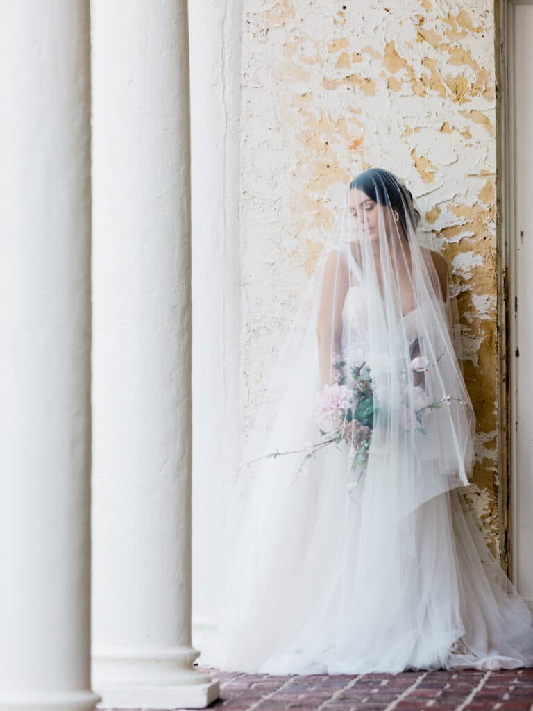bride against pillar in beautiful gown from Definition Bridal