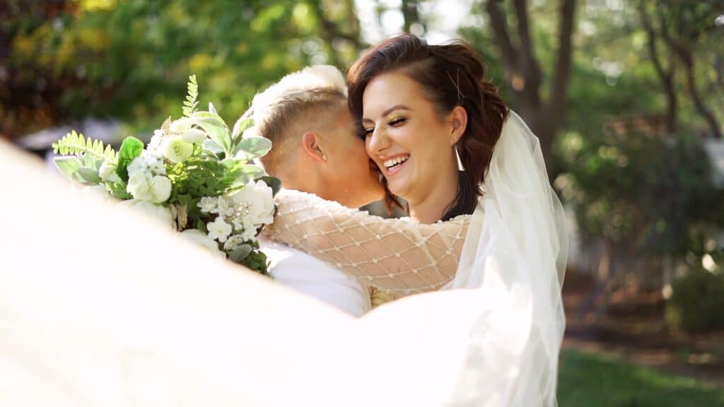 brides smiling and embracing at wedding by Lexi Rabelo Films