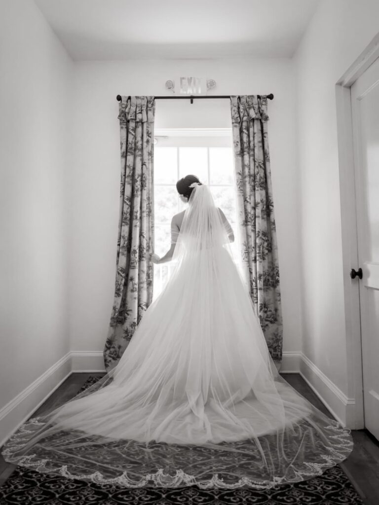 bride by window with train in beautiful gown from Definition Bridal