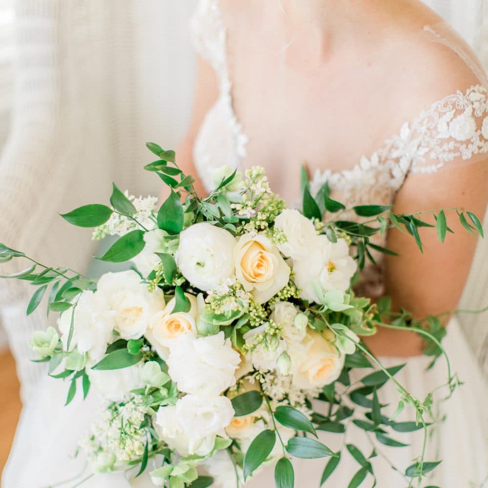 bride with white florals and greenery in bouquet