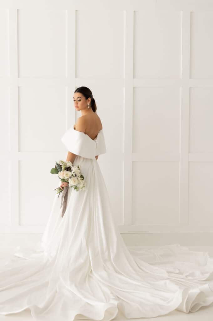bride looking over shoulder in beautiful gown from Definition Bridal