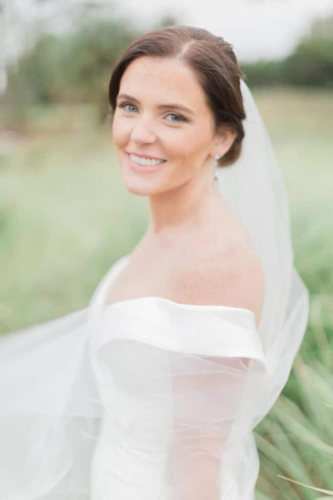 bride in off the shoulder gown looking at the camera