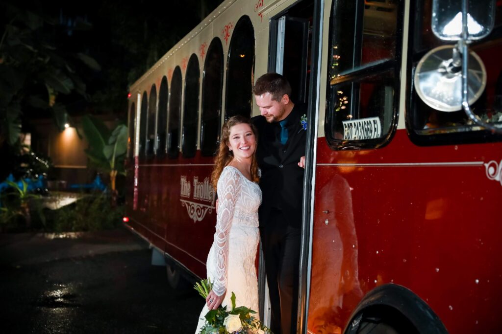 Bride and groom posing on a red trolley