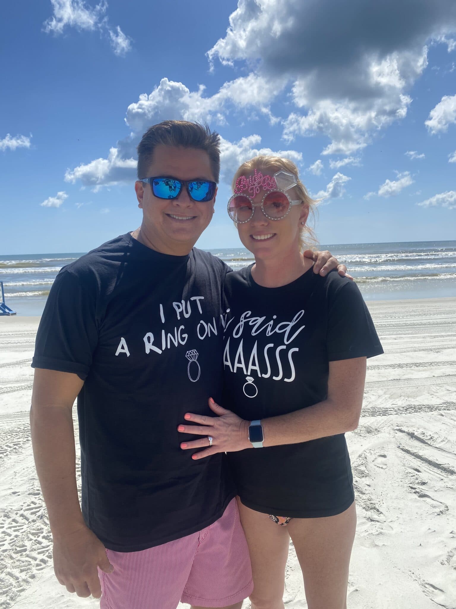couple on beach celebrating engagement