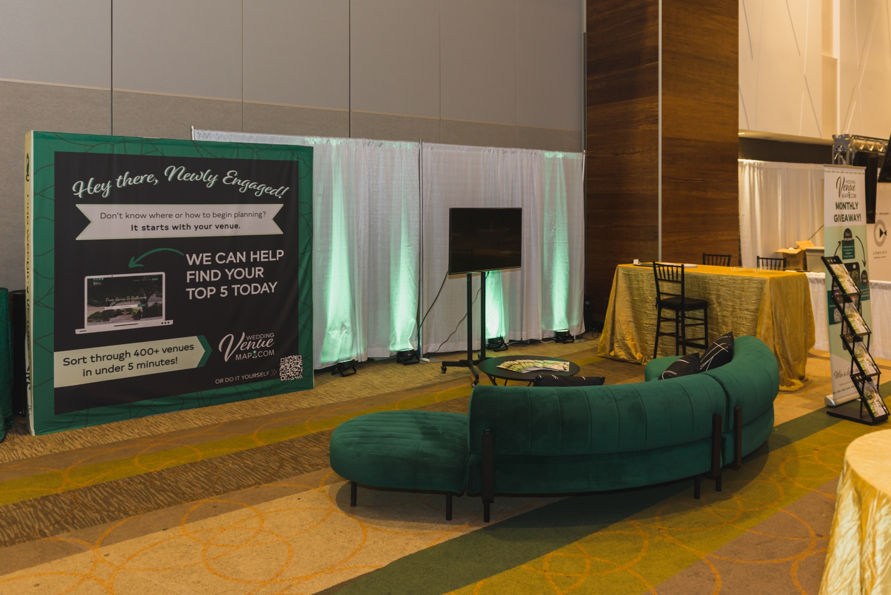 stunning green coach by Cort Furniture Rental at wedding booth at The Venue Experience at the Florida Wedding Expo