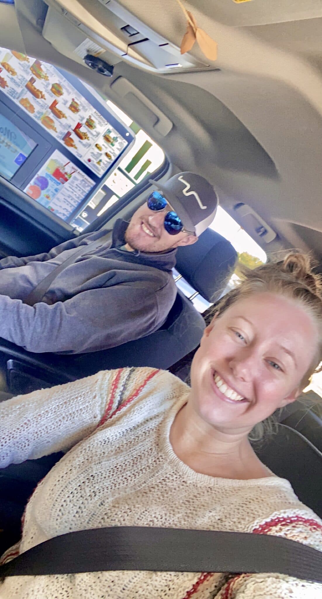 selfie of couple smiling in car going through a drive thru