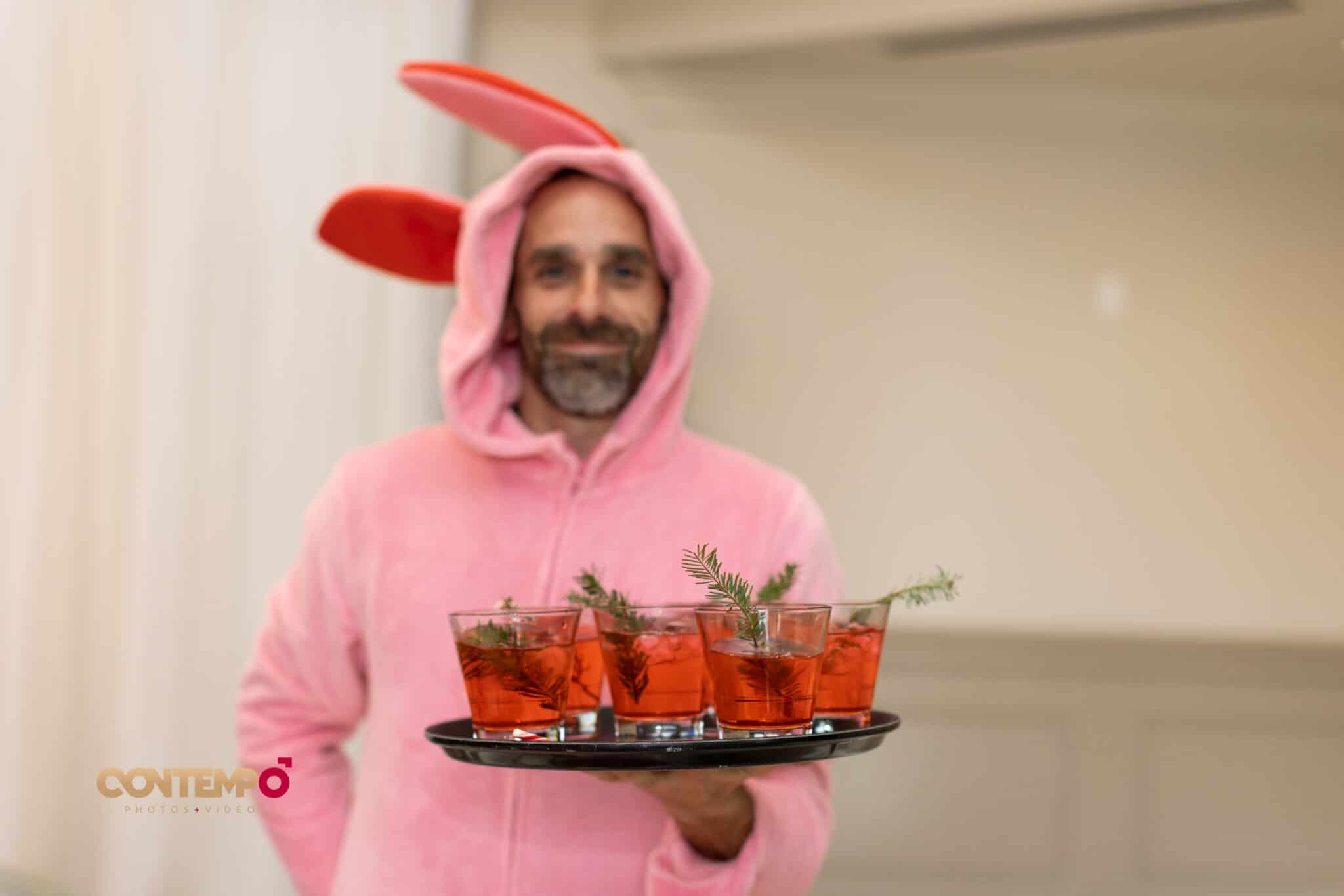 man in bunny suit serving drinks for holiday party