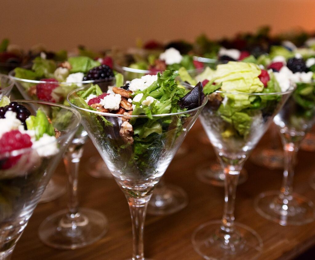 salad with roasted pecans, feta cheese and raspberries in martini glass by Puff 'n Stuff Catering