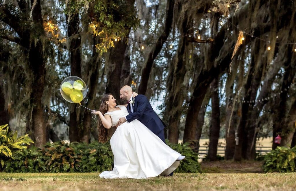 groom dipping bride with a Mickey Mouse balloon