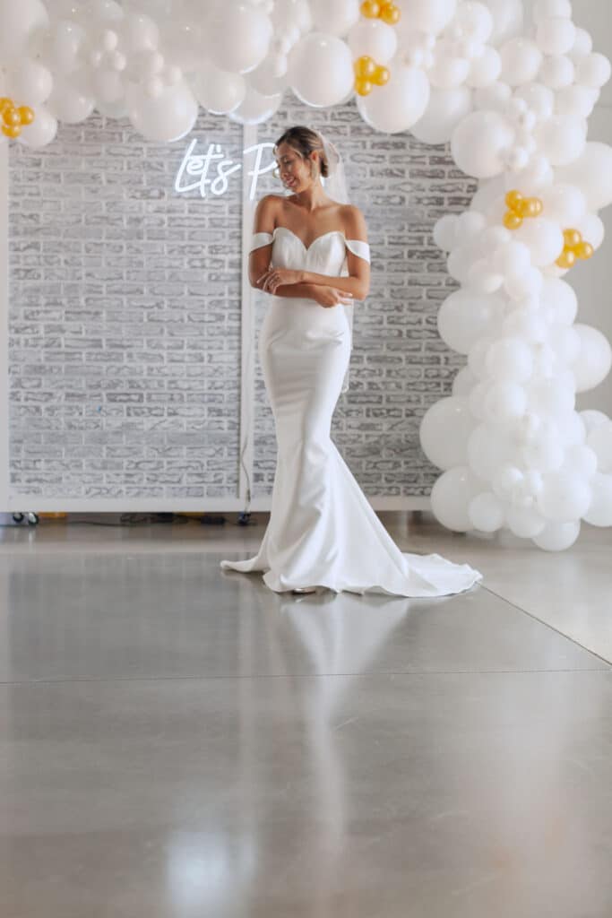 at D'Space Orlando bride posing under white and gold balloon arch