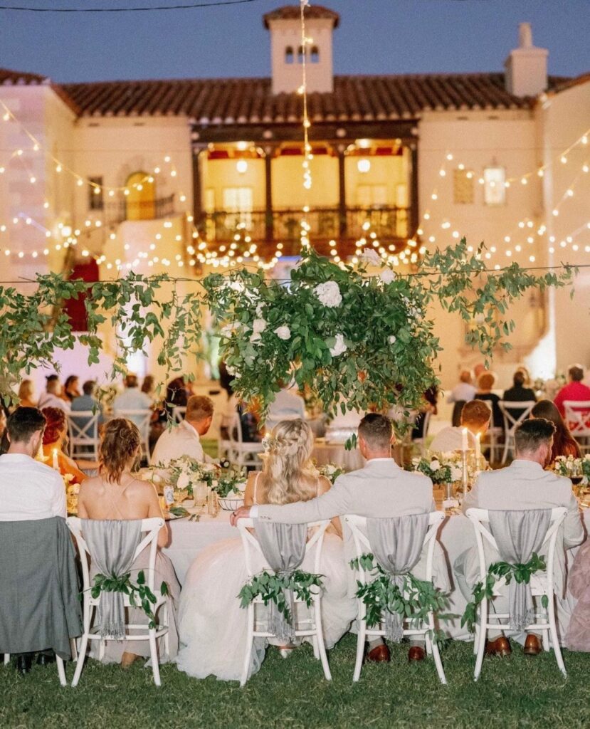 outdoor table setting with market fairy lights and greenery on the dance floor by Puff 'n Stuff Catering