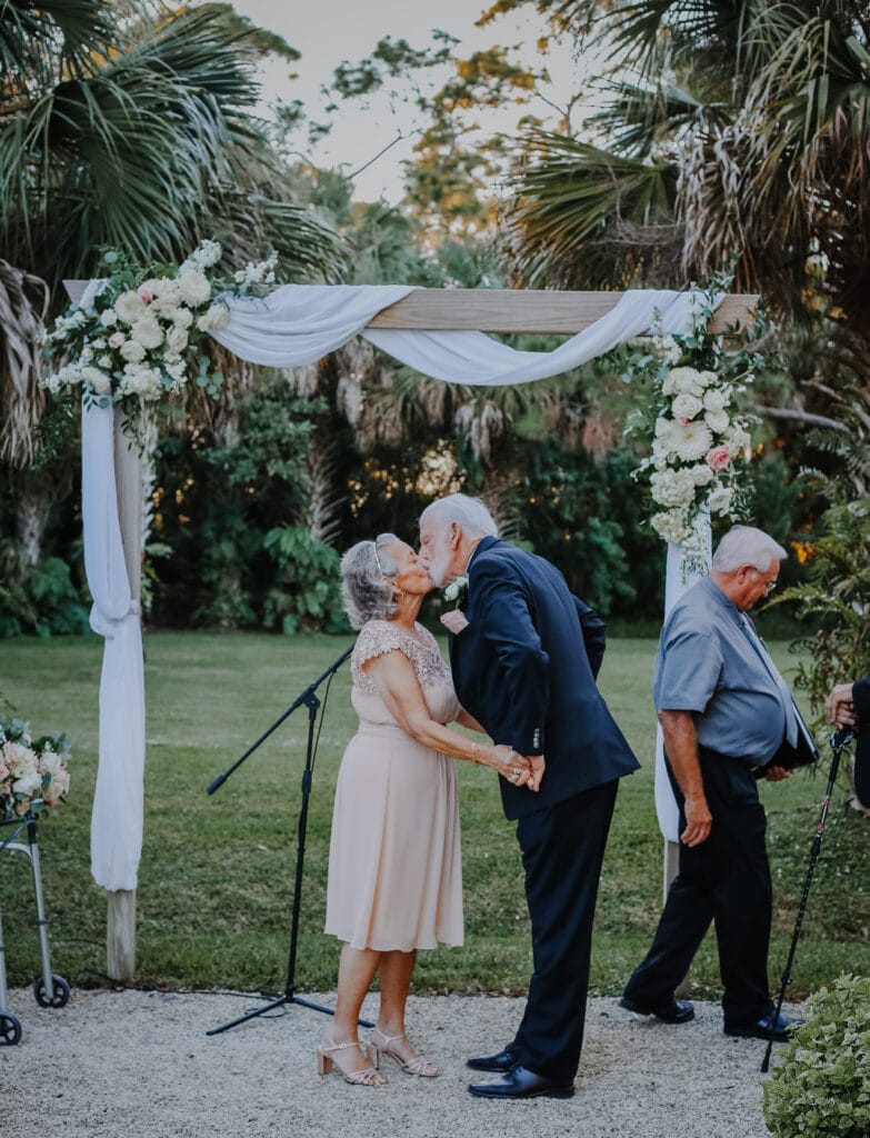 photo by Carolina Irais Photography of older couple getting married and kissing in an outdoor ceremony