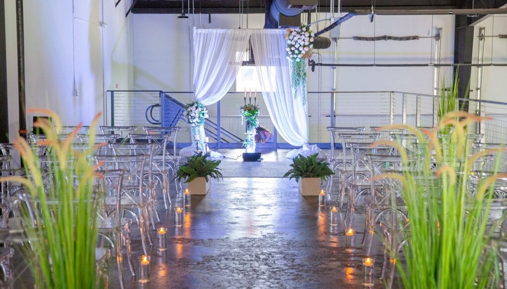 draped wedding ceremony with candles on concrete floor aisle in industrial building at D'Space Orlando