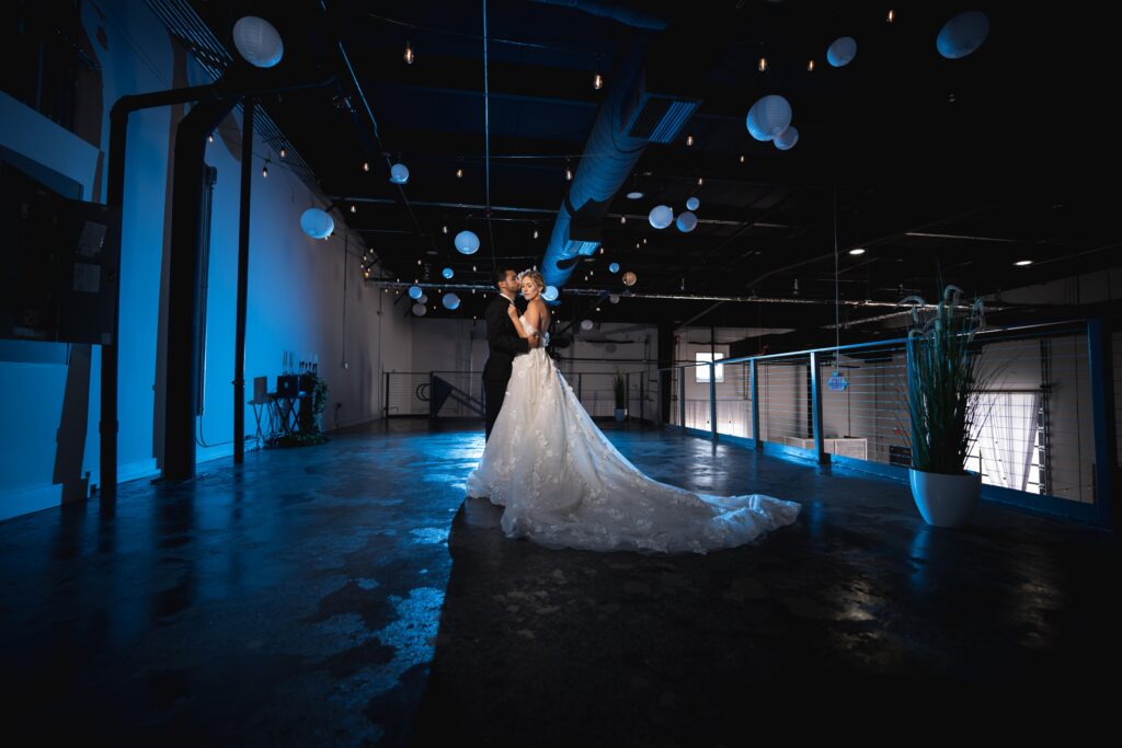 bride and groom dancing in industrial room with blue lighting at D'Space Orlando