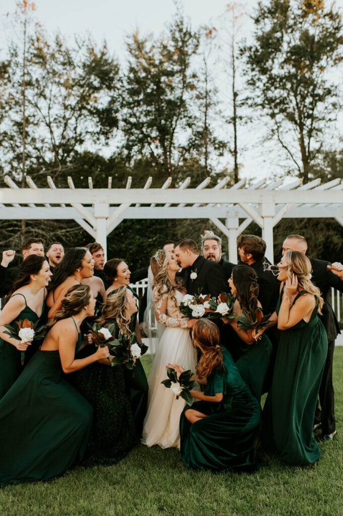 bride and groom surrounded by wedding party by Joanna Moore Photography