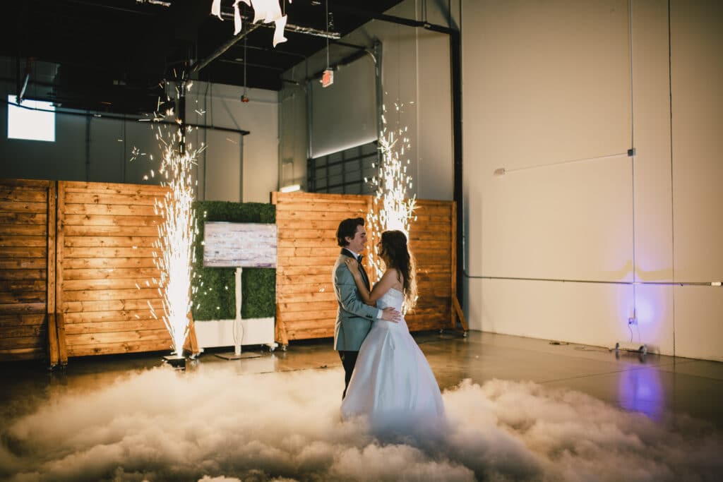 bride and groom dancing on cloud with pillar fireworks lighting the room at D'Space Orlando