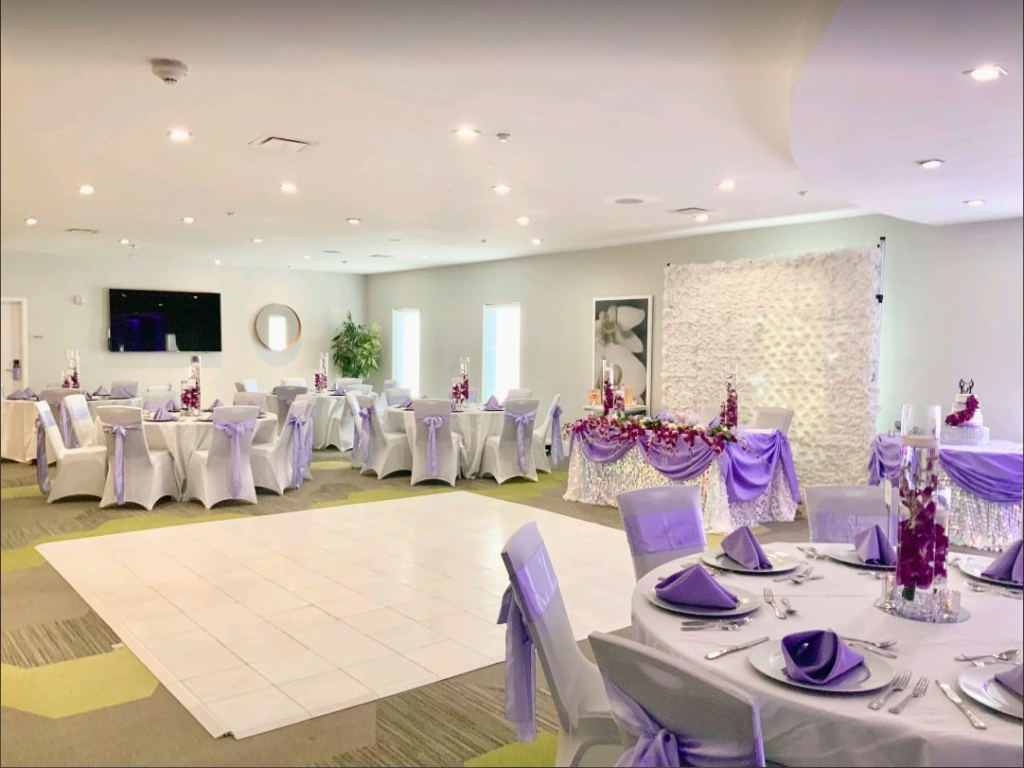 reception room with sweetheart table and rounds all set with lavender accents at Avanti International Resort