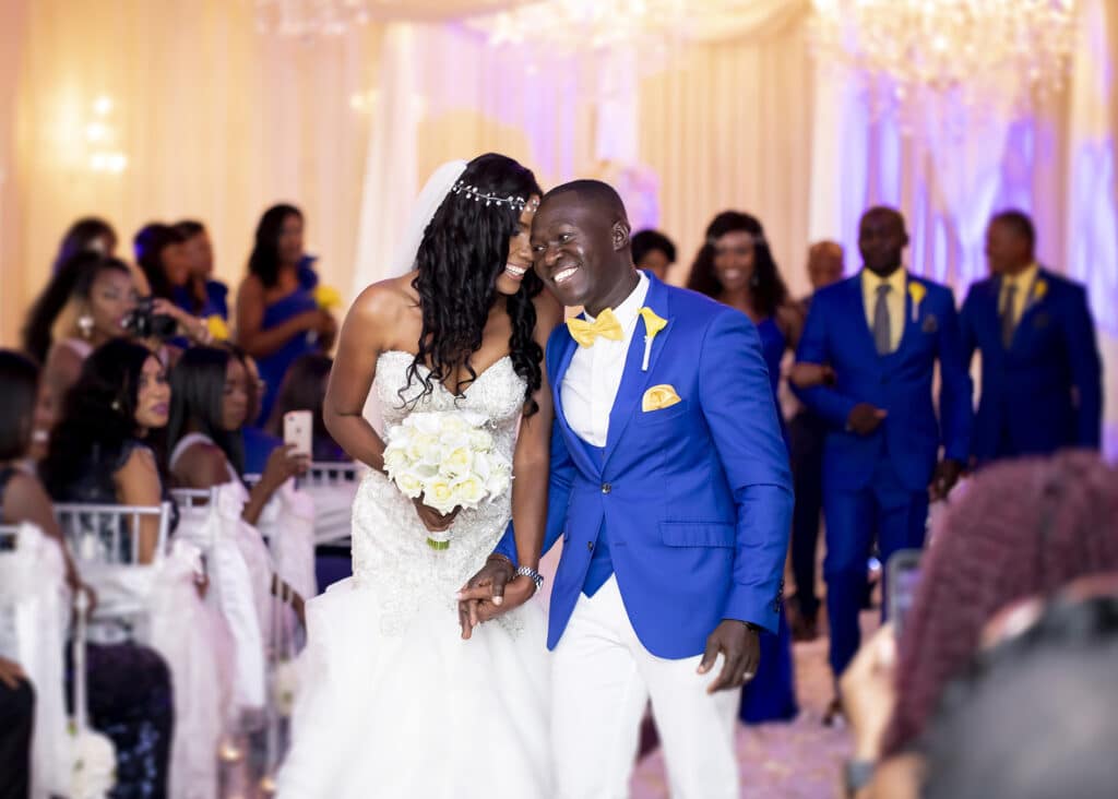 Bride and groom in royal blue jacket with yellow accents photographed by Sterling Photography International
