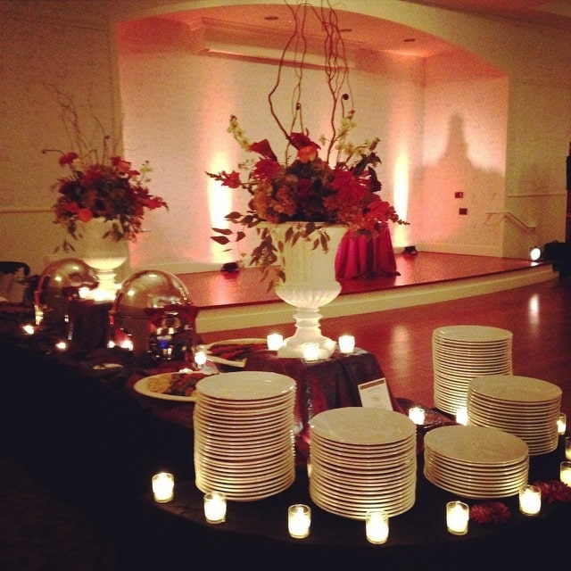 red, black and white accented table with large white vases and red florals presented by Cuisiniers Catered Cuisine and Events