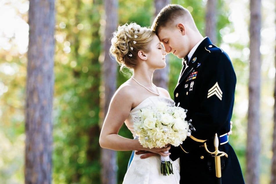 man in uniform with bride with updo by Hair Logic Beauty Bar