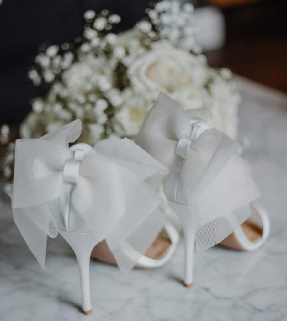 photo by Carolina Irais Photography of wedding pump with organza bow and wedding bouquet of white roses