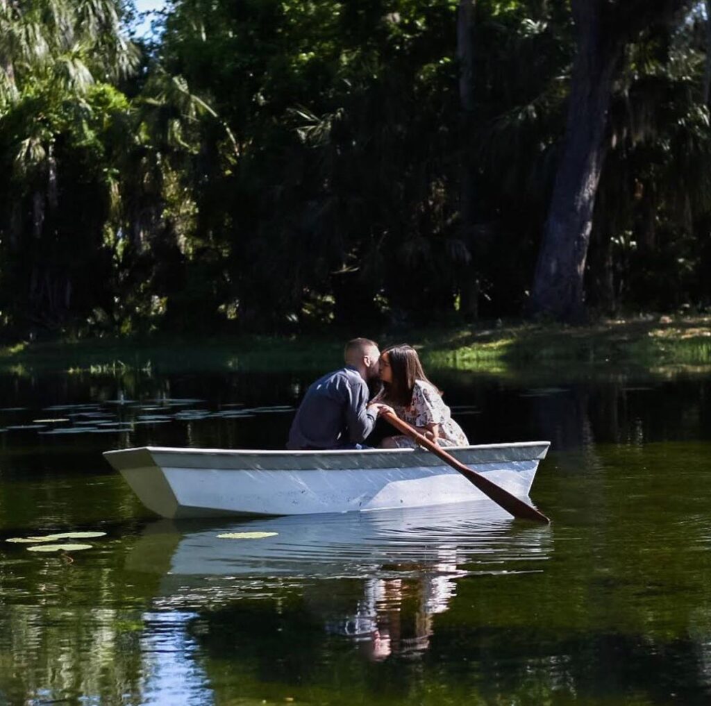 couple kissing in rowboat at their wedding at The Sugar Barn at Flying Osceola Ranch