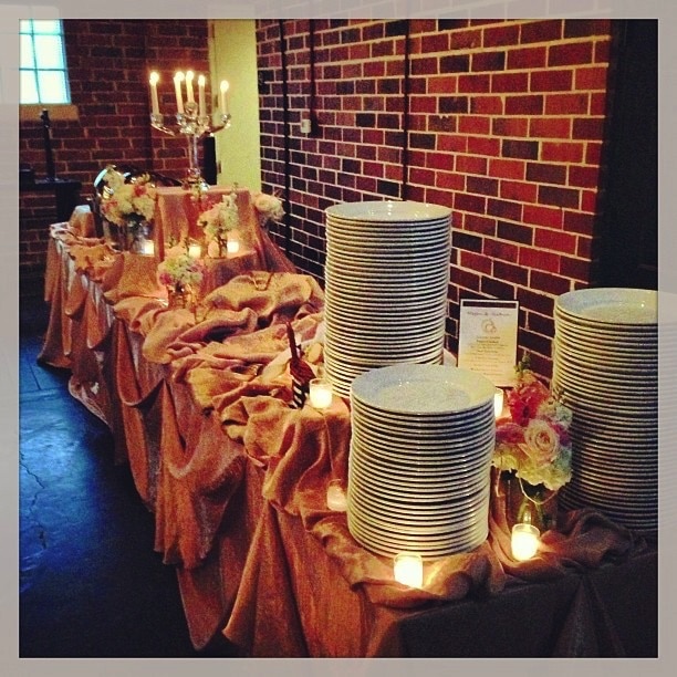 buffet table with candelabra and stacked white plates presented by Cuisiniers Catered Cuisine and Events