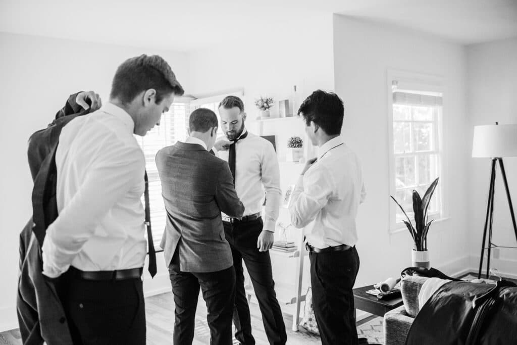 black and white photo of groomsmen getting ready for wedding by Joanna Moore Photography in Orlando, FL
