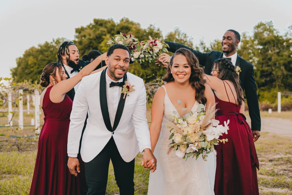 bride and groom walking down aisle after outdoor ceremony and bridesmaids are in burgundy