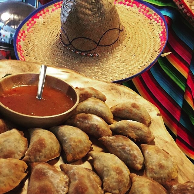 empanadas and salsa presented on serape with hat by Cuisiniers Catered Cuisine and Events