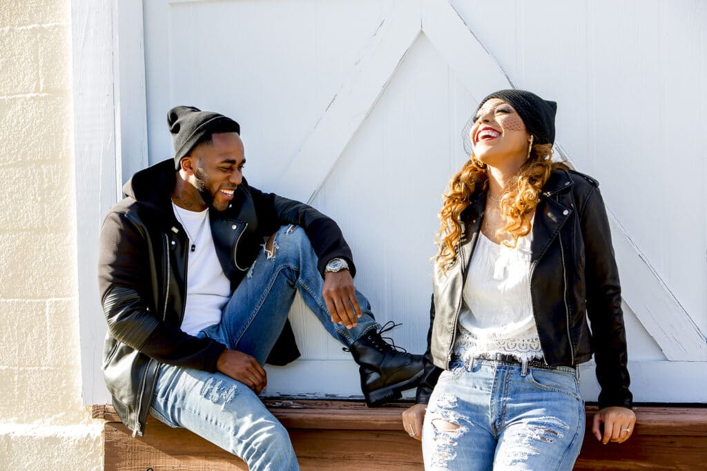 couple with black jackets and hats laughing photographed by Sterling Photography International