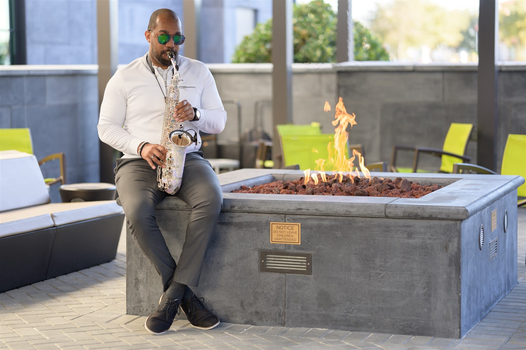 man playing saxophone next to fire pit in Winter Park Florida