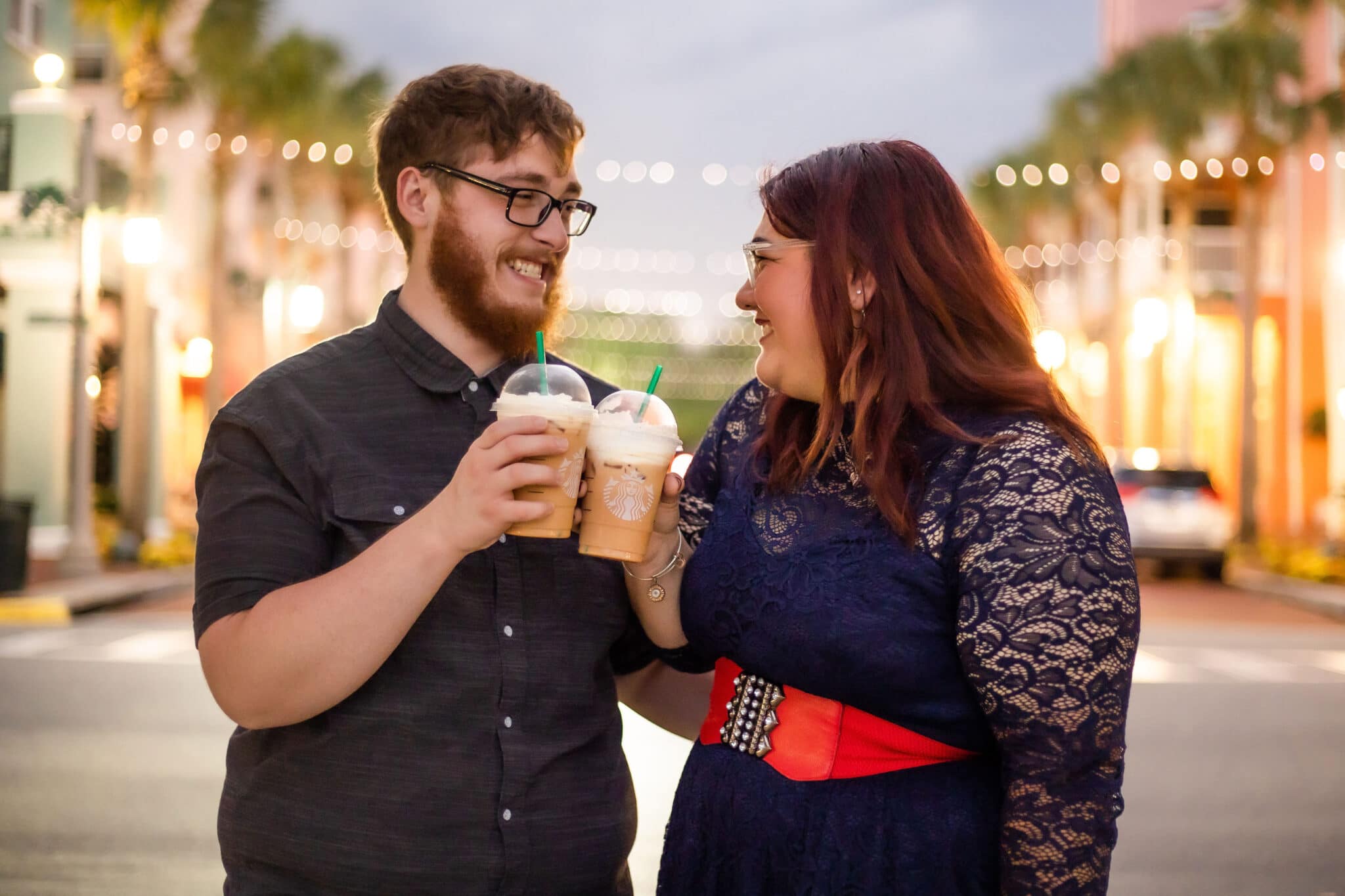 Man and woman carrying Starbucks and smiling at each other