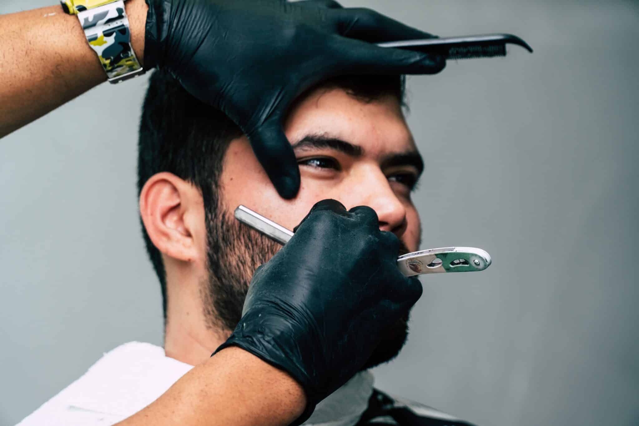 gentleman getting clean shave with a straight edge razor for Essential Pre-Wedding Grooming Treatments