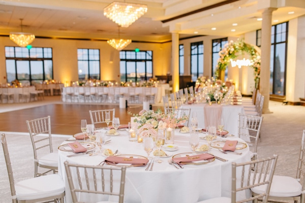 Indoor reception with small centerpieces and white tables