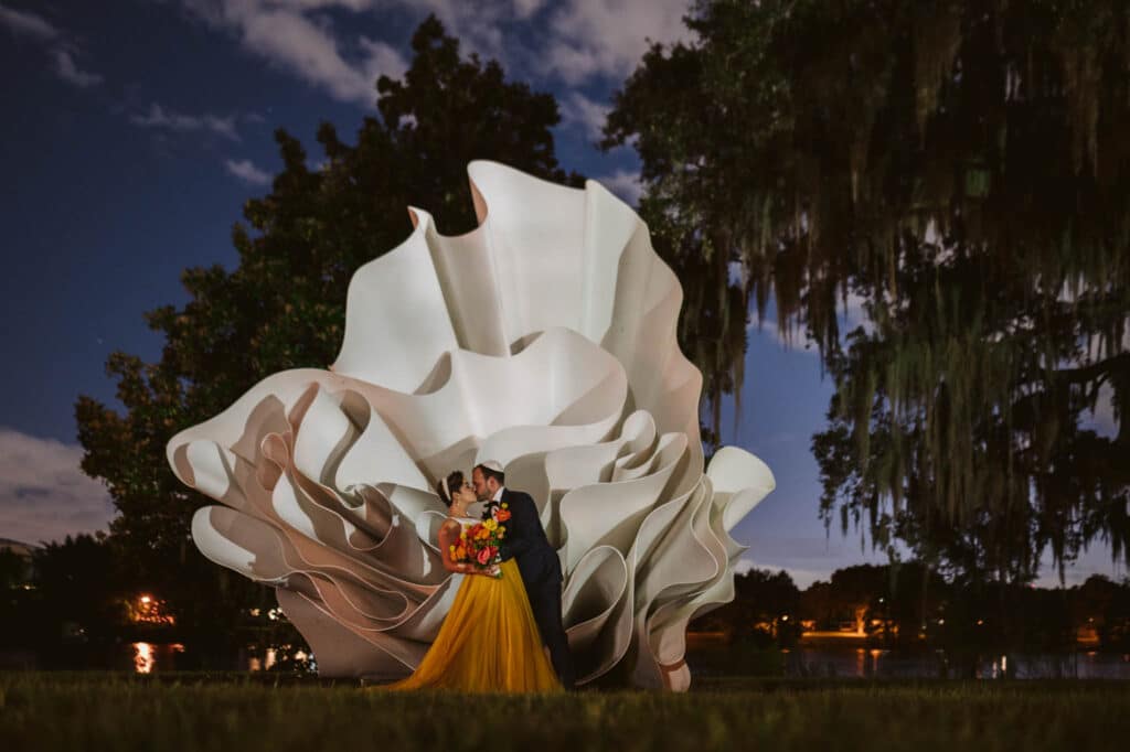 bride and groom photographed in front of modern sculpture at sunset photo by Rudy and Marta Photography