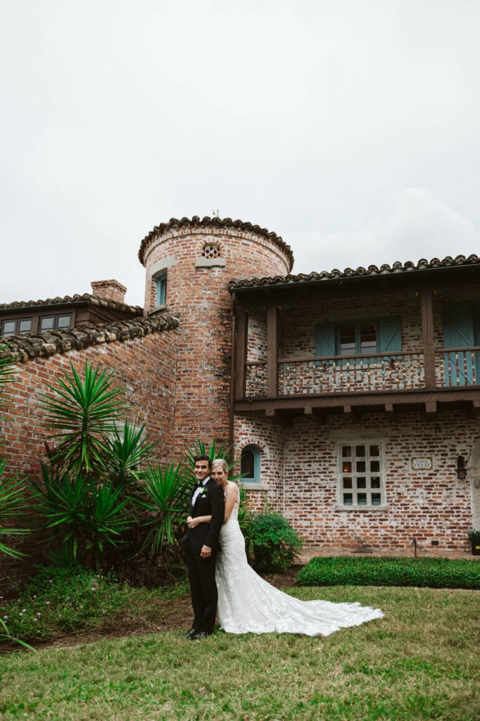 bride and groom hugging in front of stone building photo by Rudy and Marta Photography